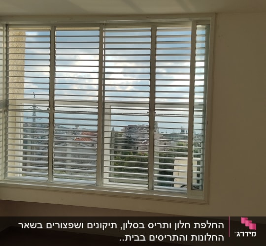 תריסי אלומיניום בחלון גדול עם נוף חיצוני